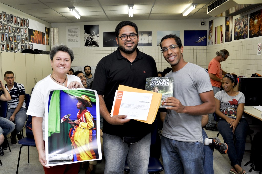 Douglas Fagner vencedor do juri técnico, recebe o prêmio da coordenadora Renata Victor e o brinde da Escambo, representado por Helder Cruz, da Escola Pernambucana de Fotografia.