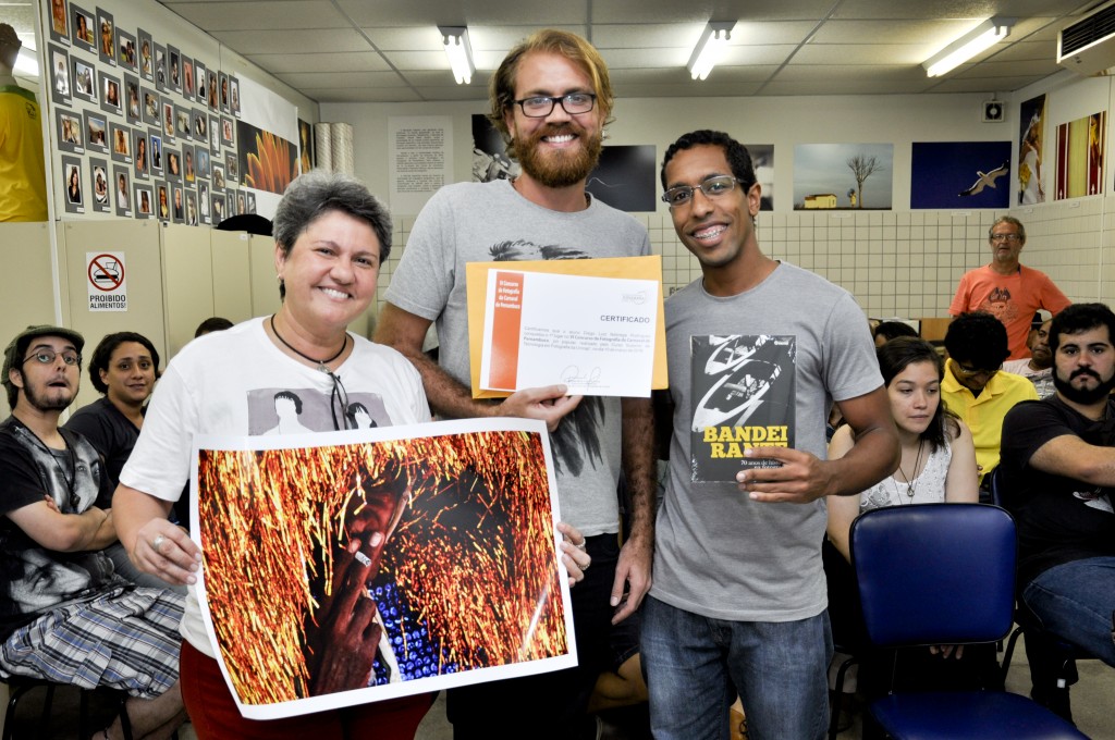 Diego Nóbrega vencedor do juri popular, recebe o prêmio da coordenadora Renata Victor e o brinde da Escambo representado por Helder Cruz da Escola Pernambucana de  Fotografia.